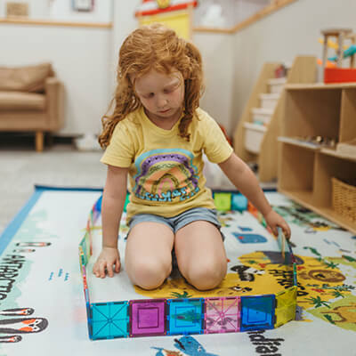 Girl playing with magnetic cubes