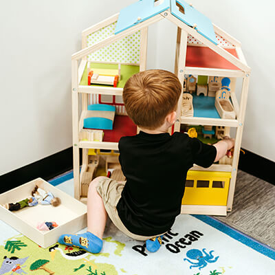 Boy playing with a miniature house